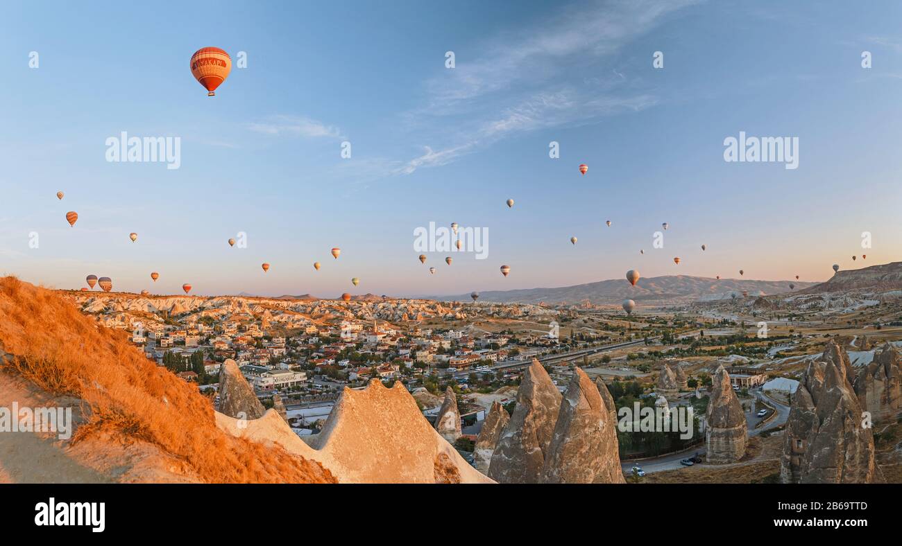 SEPTEMBER 2017, GOREME, CAPPADOCIA, TURKEY: Thousands of tourists watching at hot air balloon flying over rock landscape Stock Photo