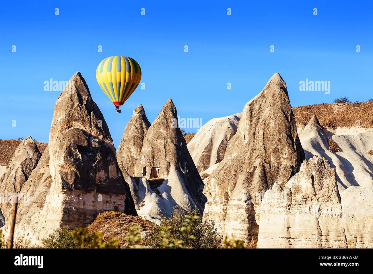 Colorful Hot air balloon flying over rock landscape at Cappadocia ...