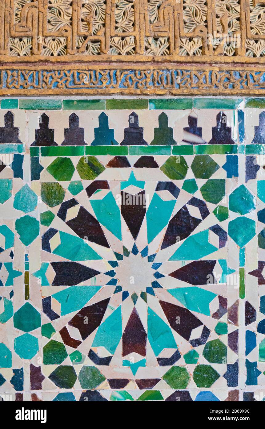 Glazed ceramic patterned tiles surmounted by yeseria plasterwork with patterns and Arabic words in the Chapel of San Bartolomé, Cordoba, Cordoba Provi Stock Photo