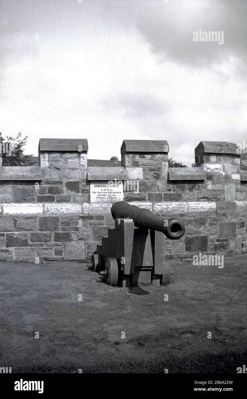 1950s, historical, Outside castle walls, an Armada Cannon dating from A. D 1588, with an inscription tablet of Captain Enthoven, Bideford, England. UK. A cannon was an artillery gun using a propellant, gunpower, to fire a projectile, a cannonball. Stock Photo