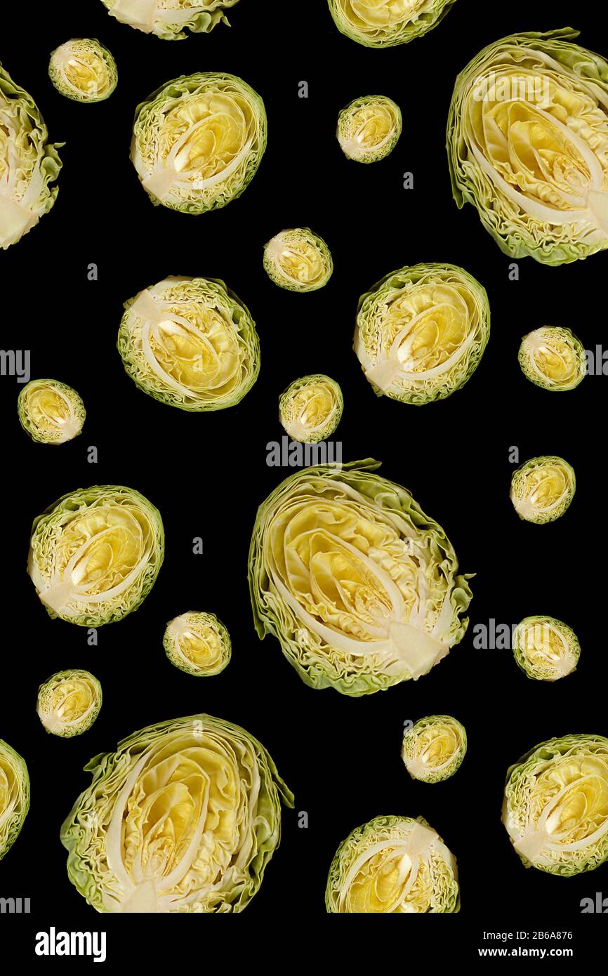 Culinary background. Halfs of cut white cabbage isolated on black background. Seamless pattern. Backdrop for design Stock Photo