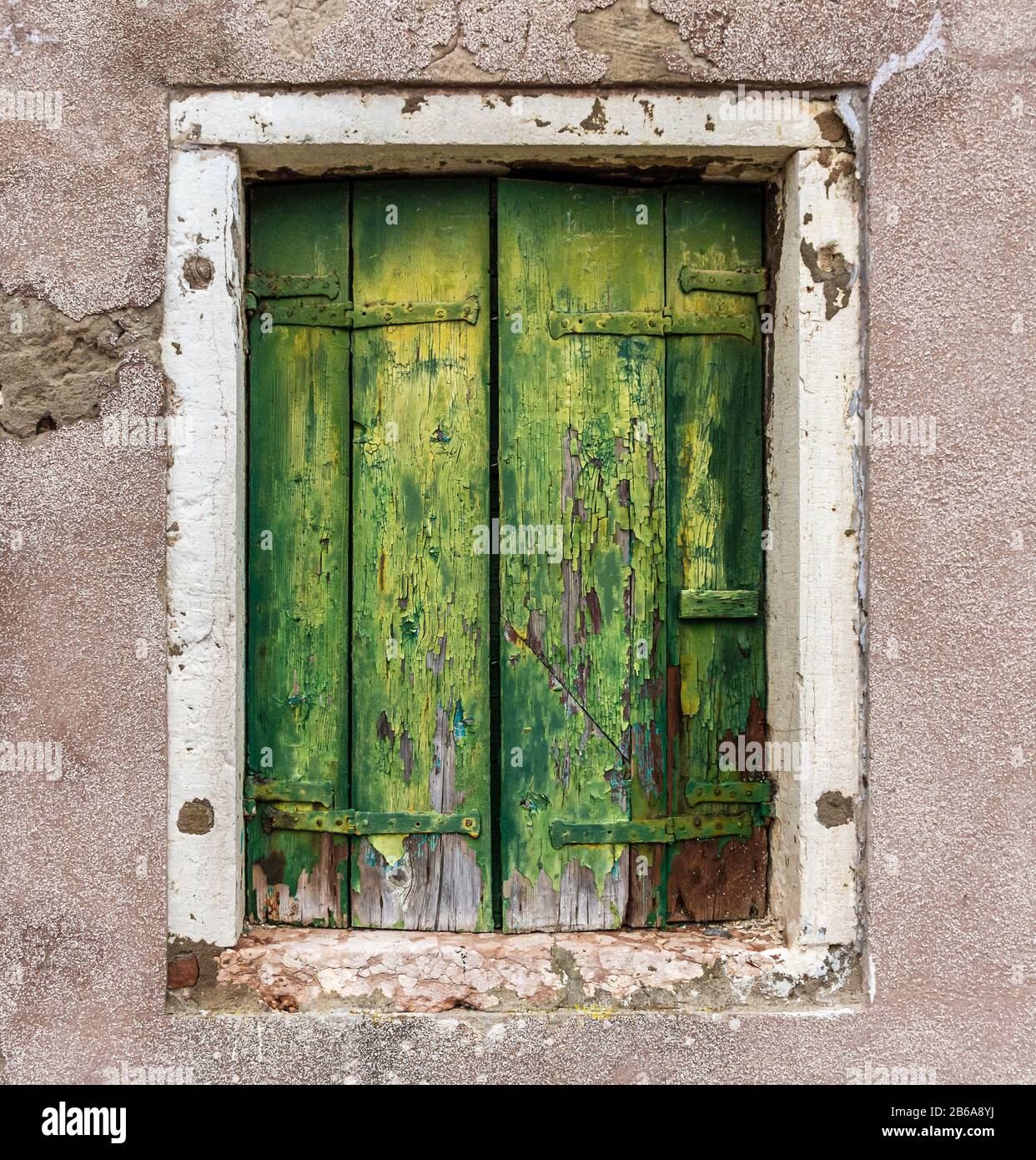 Old green weathered wooden shutters with a white window frame, Murano ...