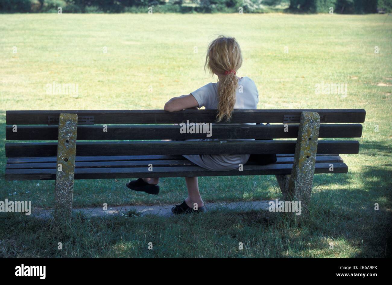 Woman sitting alone on bench hi-res stock photography and images - Alamy