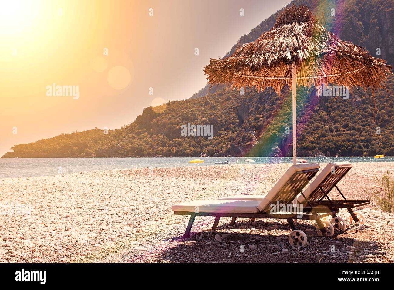 Sunshades and chaise lounges on beach. Summer seascape. Tinted toned coloration image. Selective focus Stock Photo