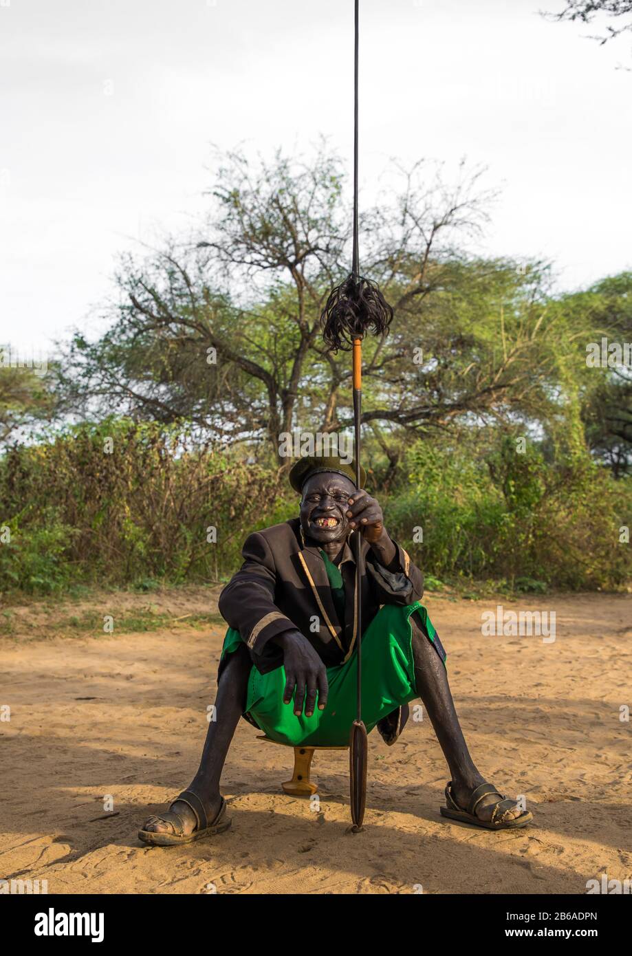 Toposa tribe man sit on a wooden pillow and holding a spear, Namorunyang State, Kapoeta, South Sudan Stock Photo
