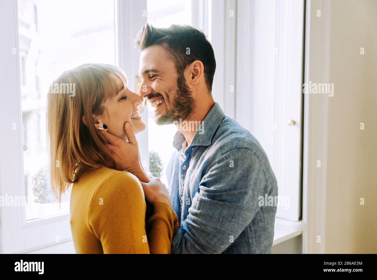 Two young adults at home - Romantic moment at home, couple of lovers kissing Stock Photo