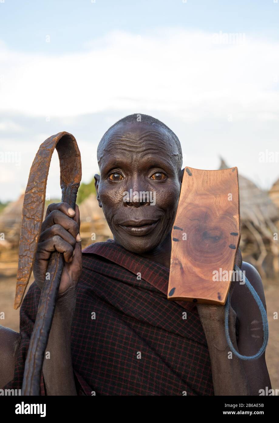 Portrait of a Toposa tribe man holding a whip and a wooden seat, Namorunyang State, Kapoeta, South Sudan Stock Photo