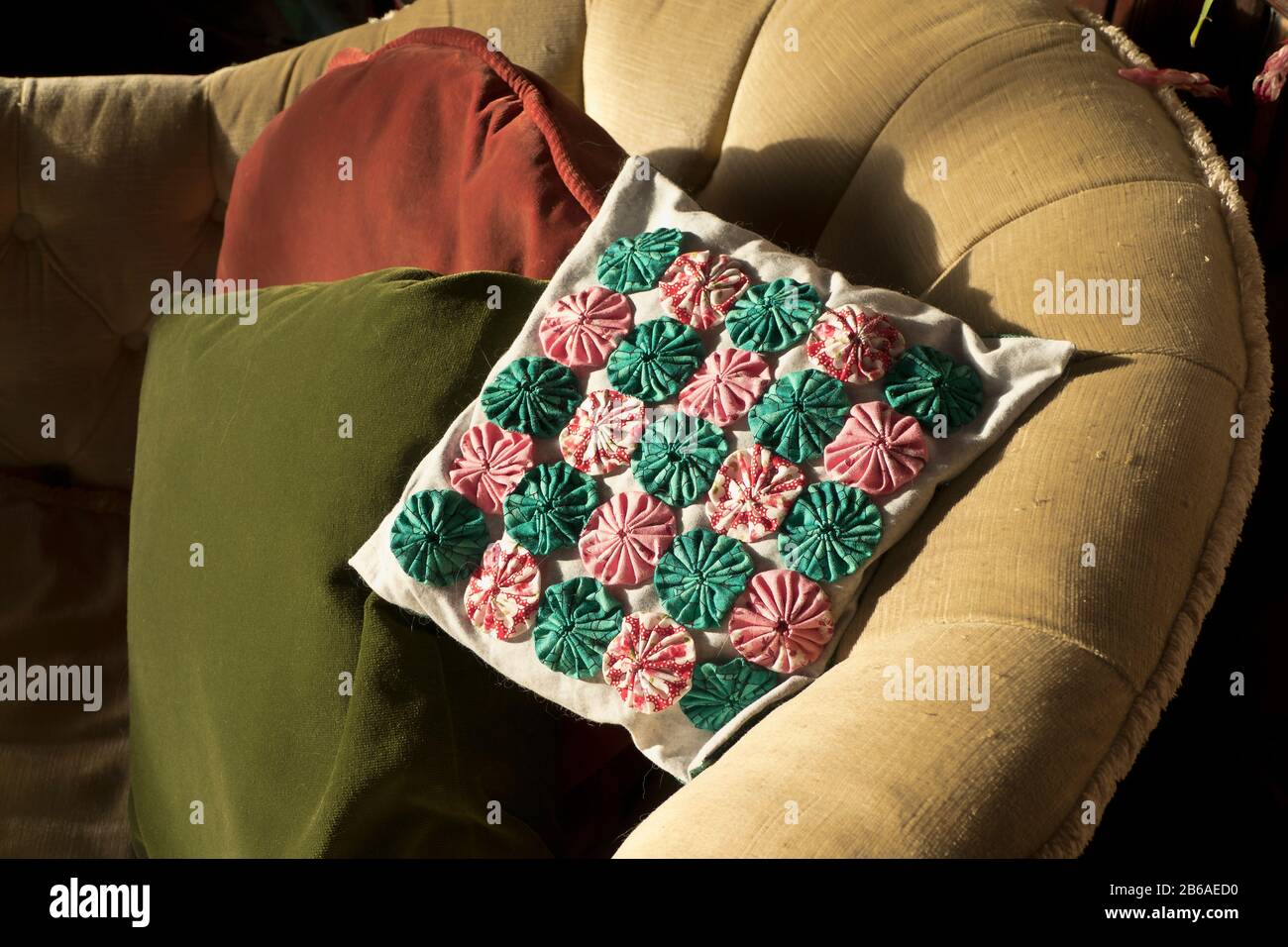Pretty home-crafted decorated chair cushion made from recycled fabrics in England UK Stock Photo