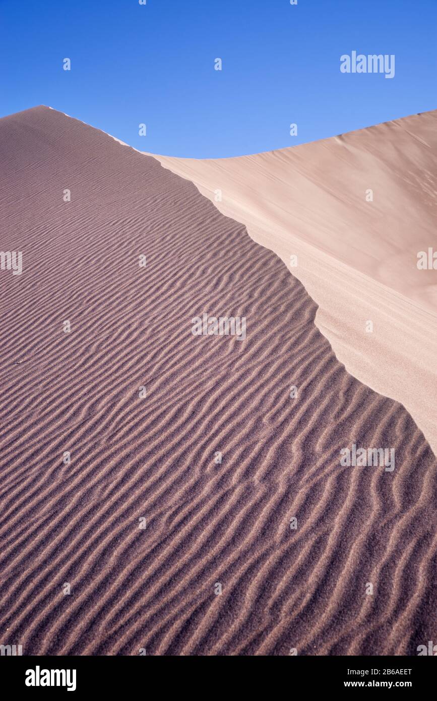 rippled sand dune at Big Dunes with blue sky above Stock Photo