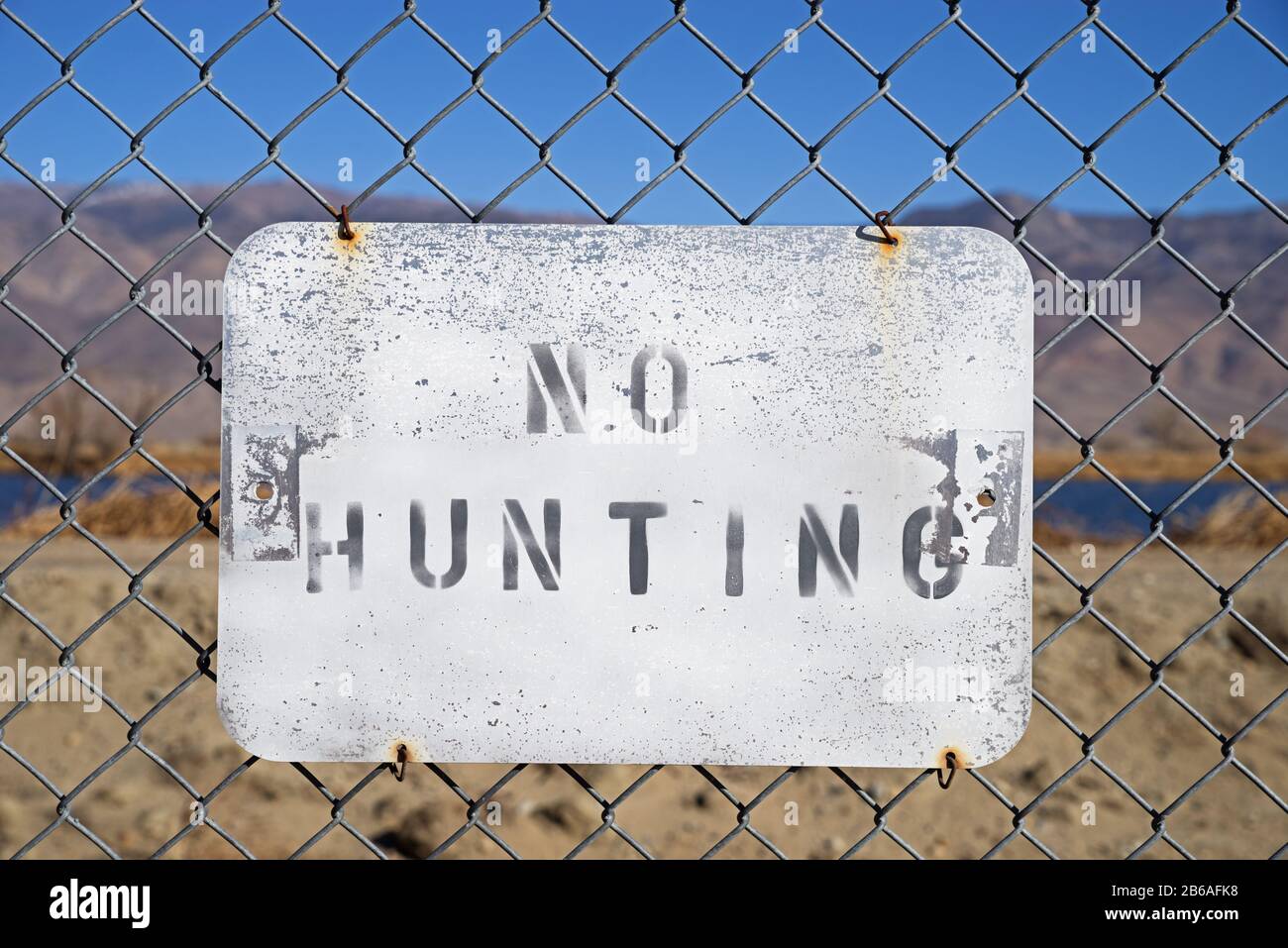 no hunting sign wired to a chain link fence Stock Photo