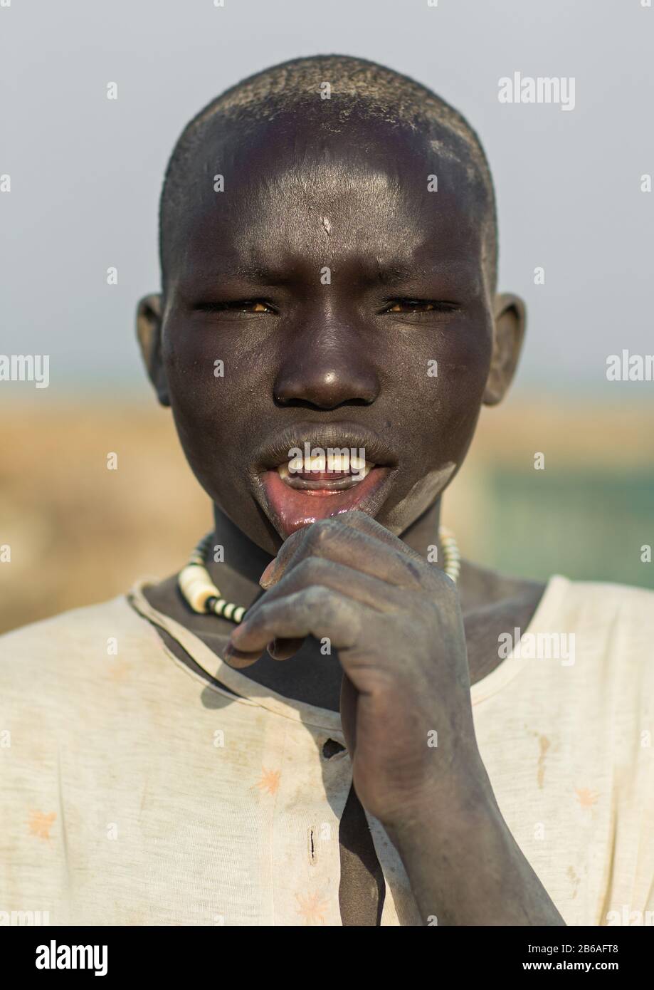 Portrait of a Mundari tribe boy shiwing his lower teeth traditionally removed, Central Equatoria, Terekeka, South Sudan Stock Photo