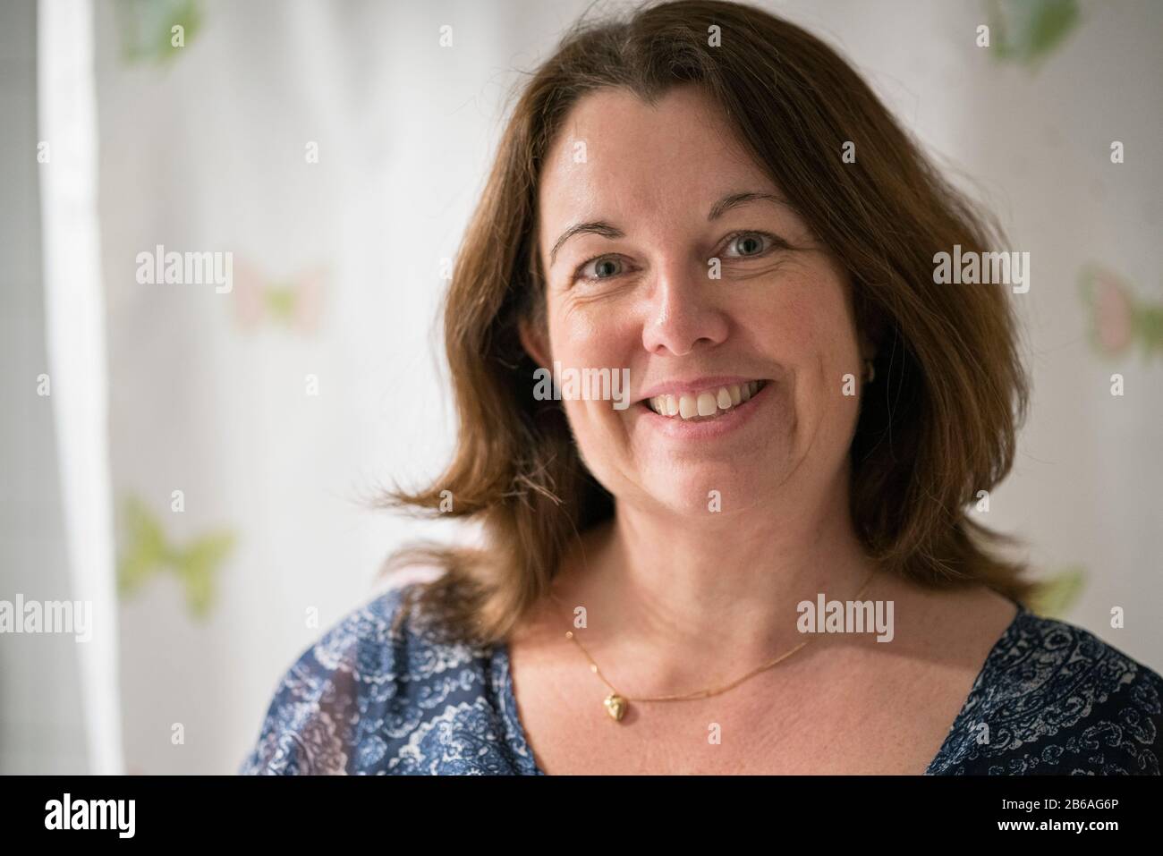Close up portrait of a smiling 50 year old woman with brown hair. Stock Photo