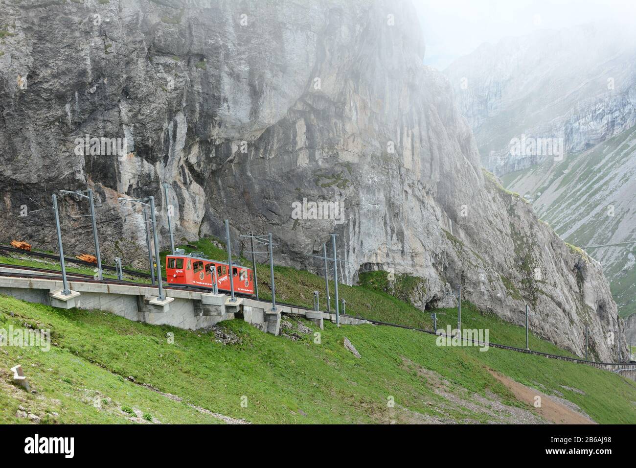 ALPNACHSTAD, SWITZERLAND - July 3, 2014: The Pilatus-Bahn, the world's steepest cogwheel railway nears the top of Mount Pilatus as it emerges from the Stock Photo