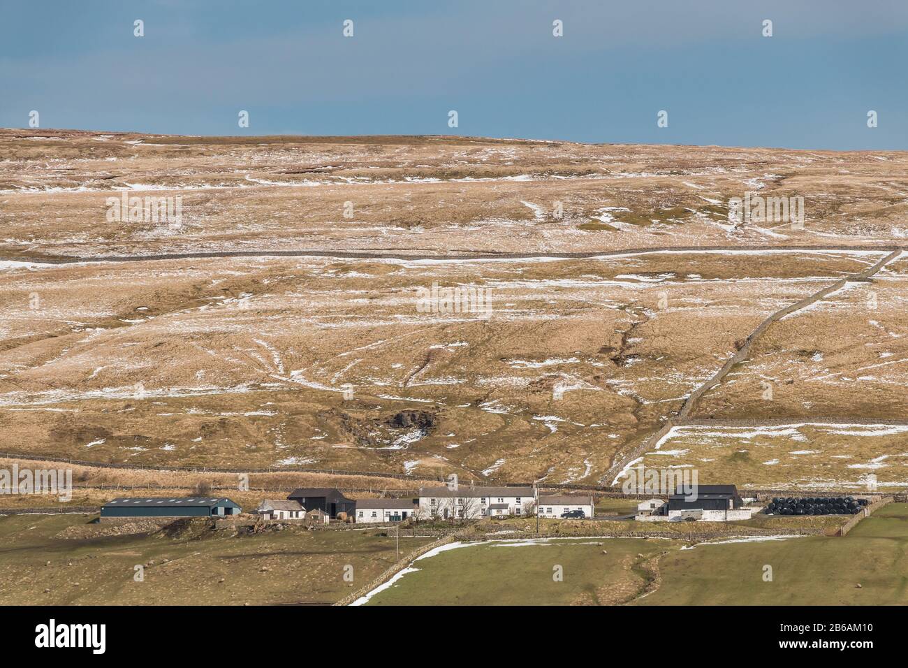 A patchy snow covered hillside emphasizing the landscape features behind Bowes Close Farm, Harwood, Upper Teesdale, UK Stock Photo