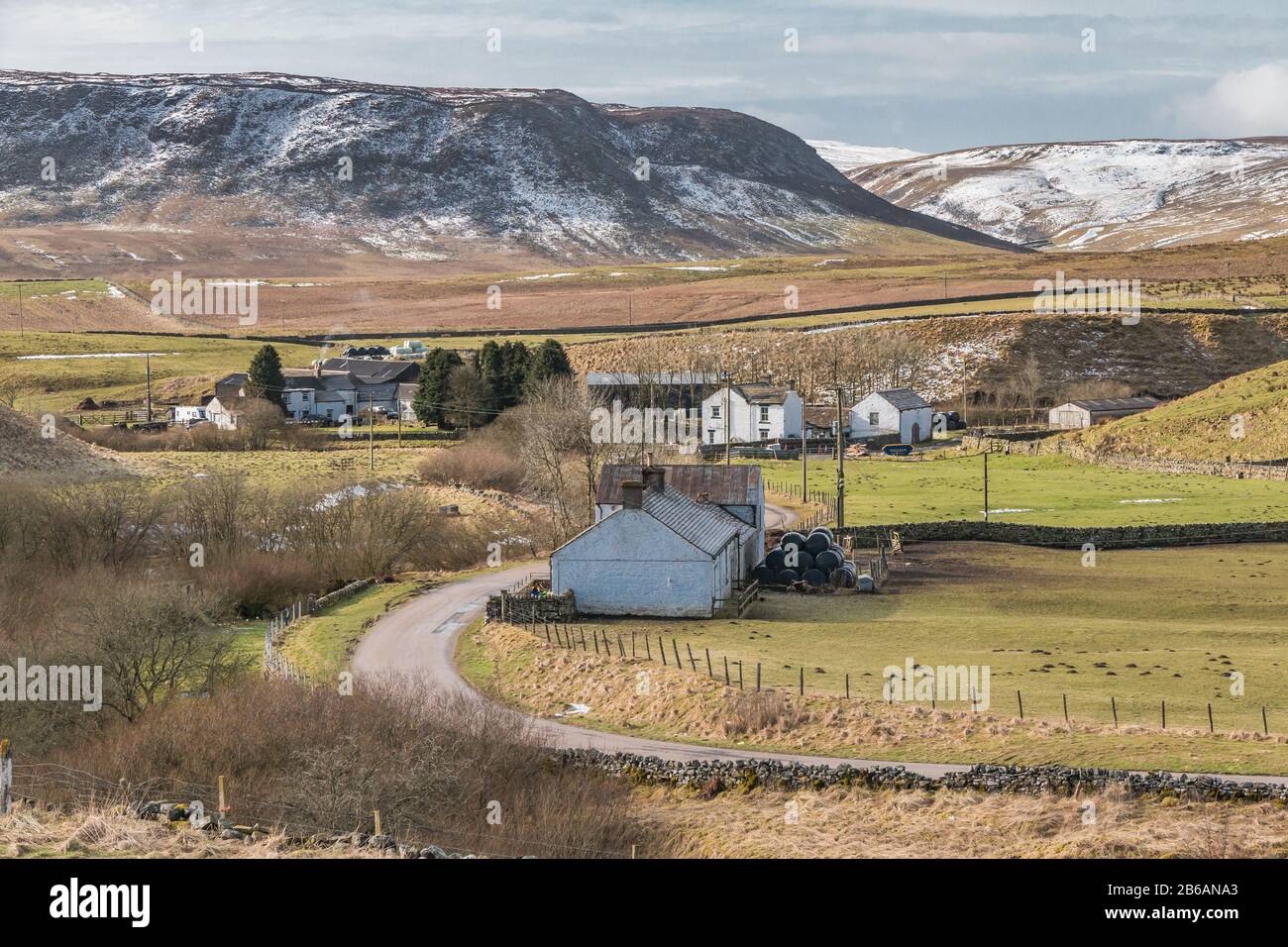 The remote farming hamlet of Langdon Beck in Upper Teesdale, with a covering of snow on the dramatic Cronkley Scar in the background. Stock Photo