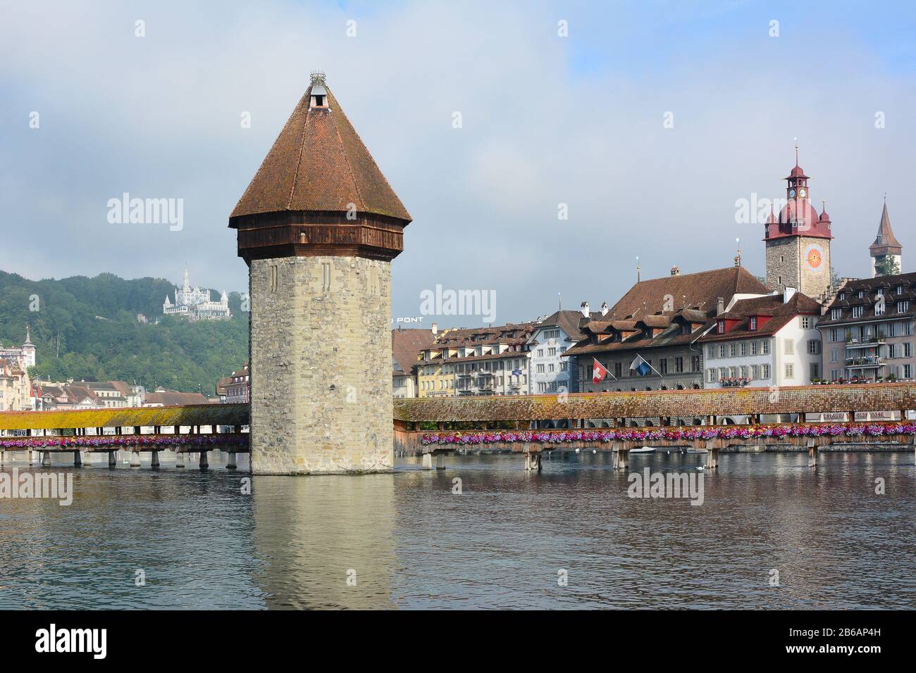 LUCERNE, SWITZERLAND - JULY 2, 2014: Chapel Bridge and Water Tower, Lucerne. The wooden covered bridge spans the Reuss River with the with Mt. Pilauts Stock Photo