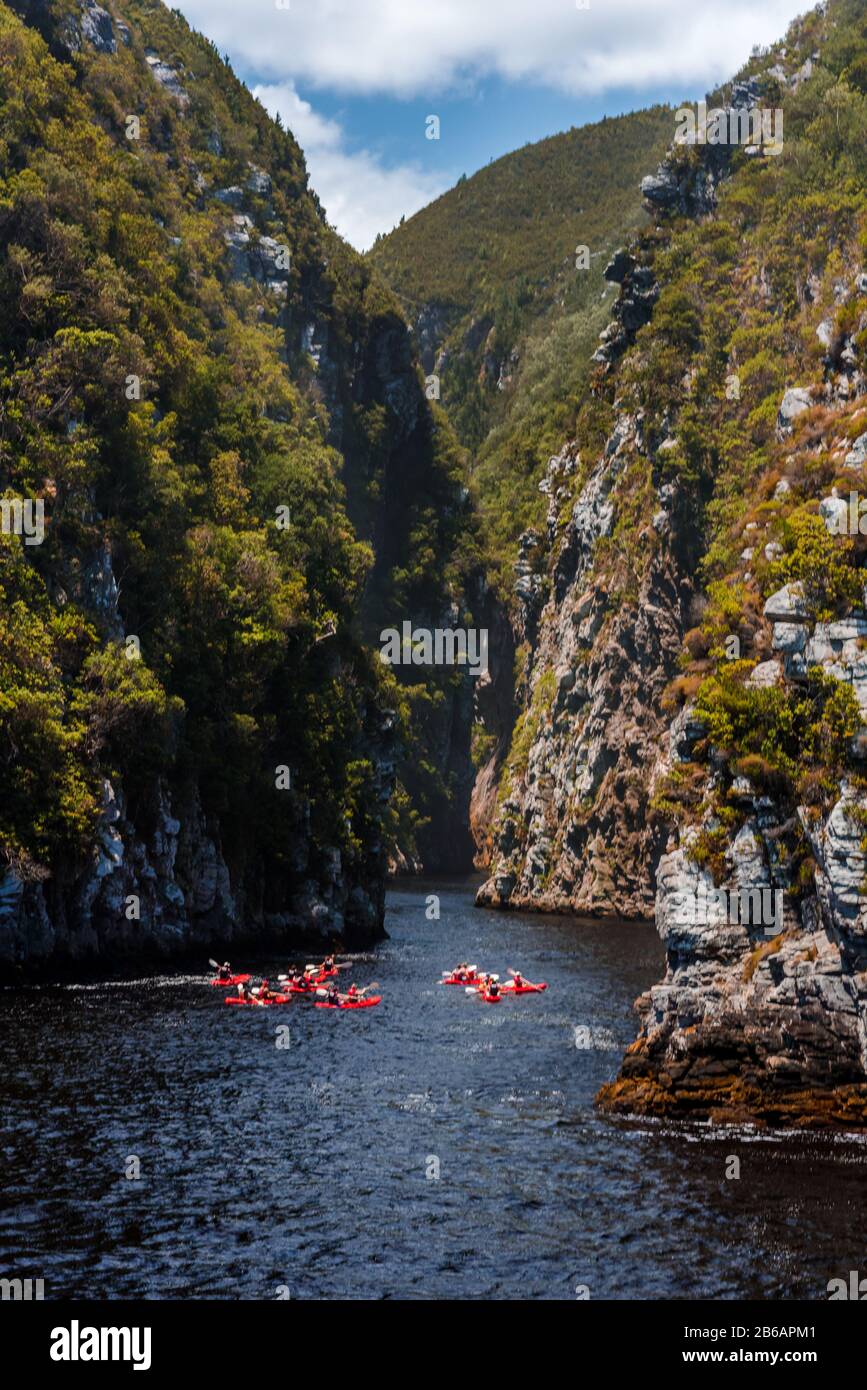 A group of people in Kayaks setting out on a tour up Storms River gorge from Storms River Mouth in Tsitsikamma along the Garden Route, South Africa Stock Photo