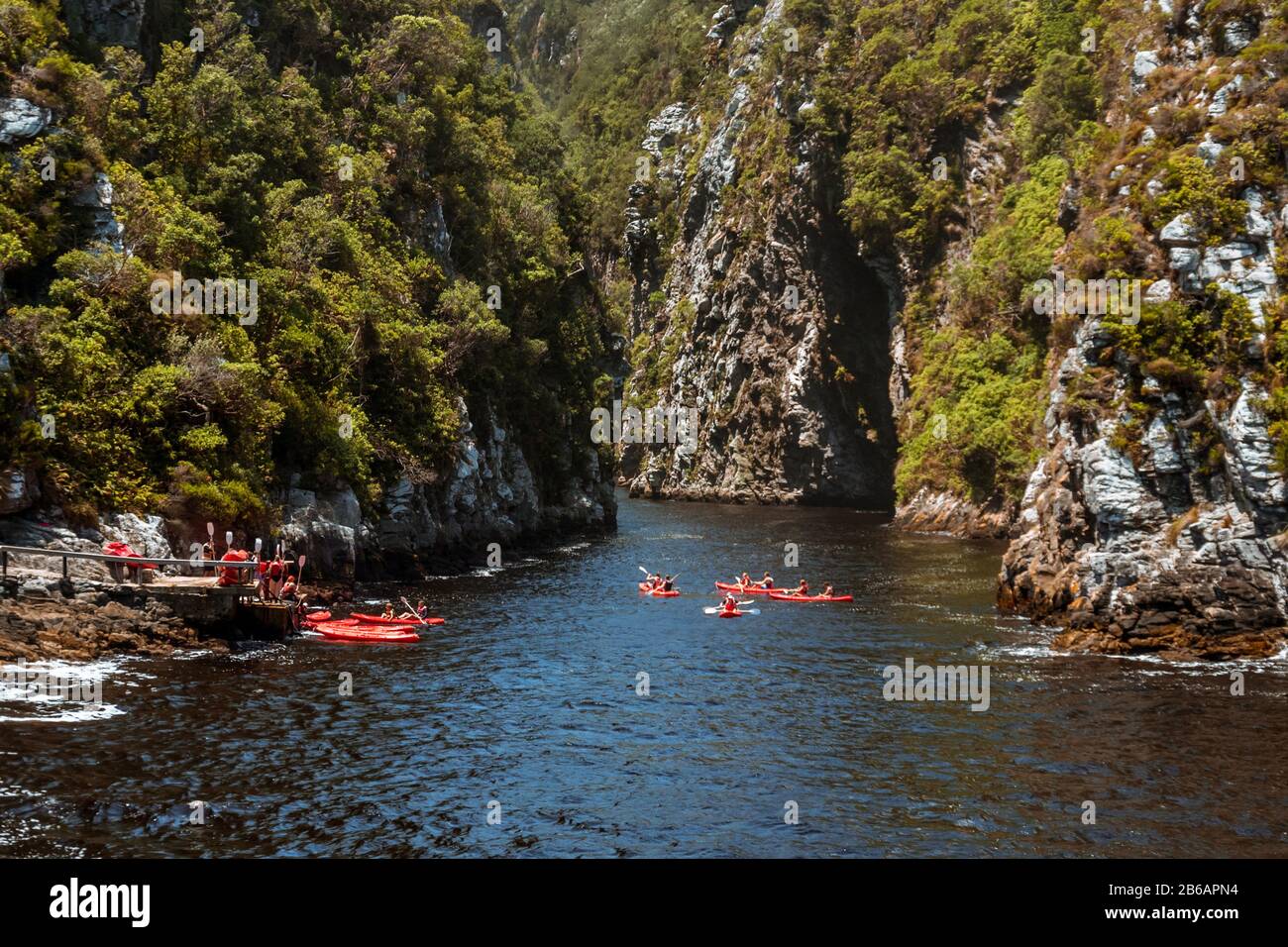 A group of people in Kayaks setting out on a tour up Storms River gorge from Storms River Mouth in Tsitsikamma along the Garden Route, South Africa Stock Photo