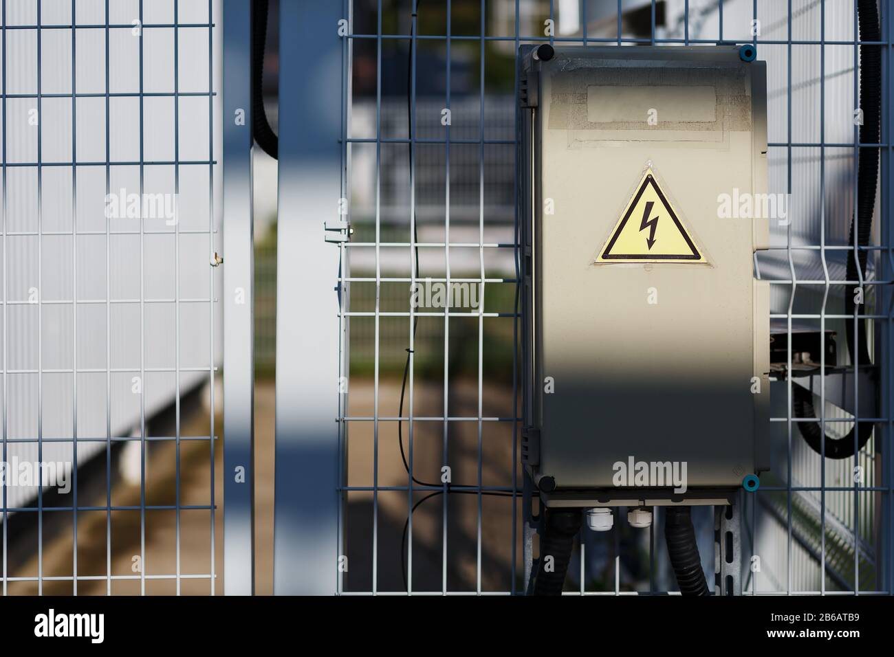 Gray hinged power supply unit on the wall, electric flap, danger sign