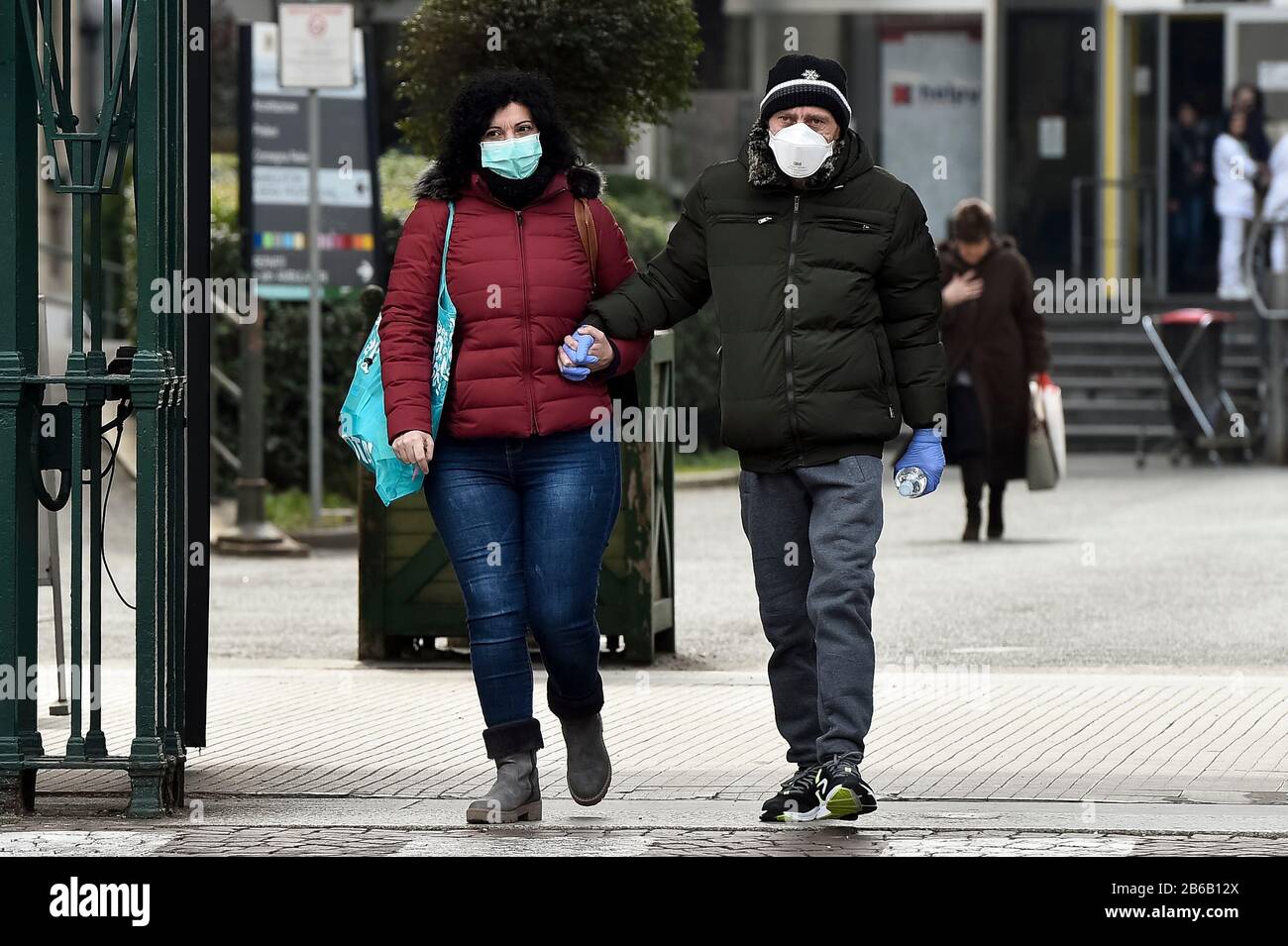 Turin, Italy. 09th Mar, 2020. TURIN, ITALY - March 09, 2020: Two people wearing protective masks and holding hands leave Molinette hospital. The Italian government imposed a virtual lockdown on the north of the country as part of measures to stop the spread of the coronavirus COVID-19 outbreak in Italy. (Photo by Nicolò Campo/Sipa USA) Credit: Sipa USA/Alamy Live News Stock Photo