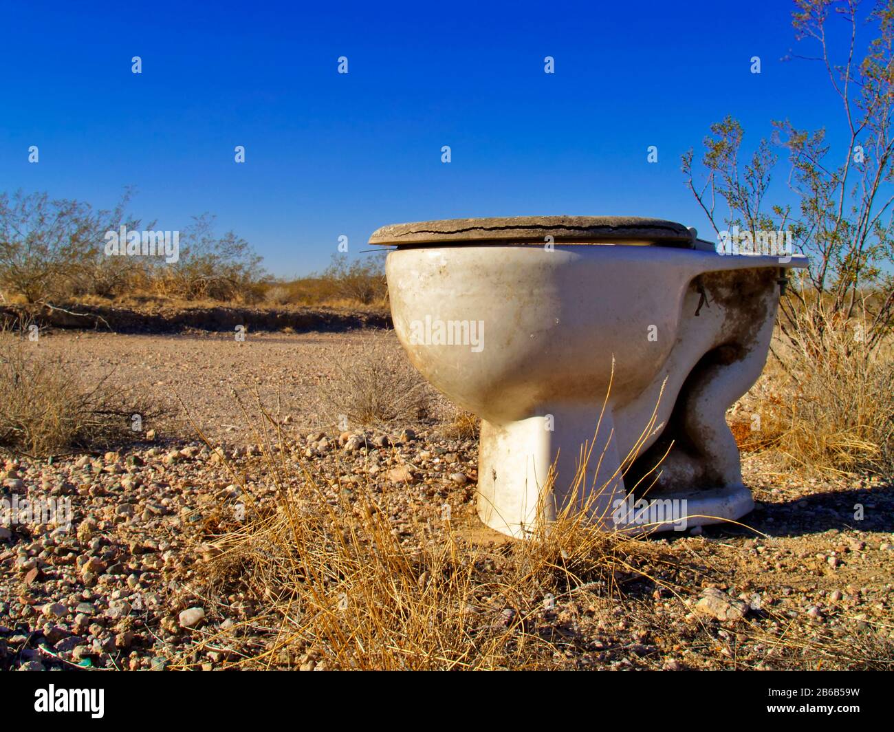 An old toilet abandoned in a remote area of the Arizona Desert. Stock Photo