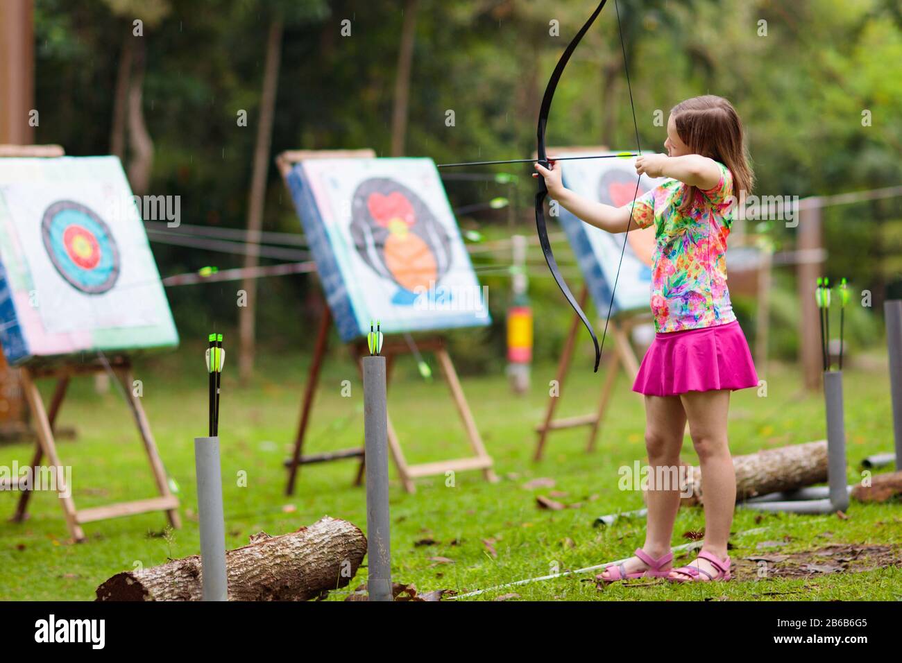 Archery for child. Little girl with bow and arrow. Kids shoot on