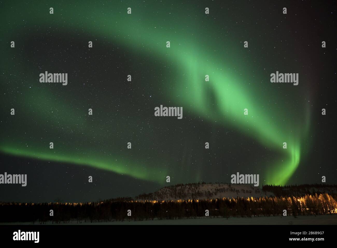 Beautiful green Northern Lights (Aurora Borealis) captured in Luosto, Lapland, Finland with clear sky and stars. Stock Photo