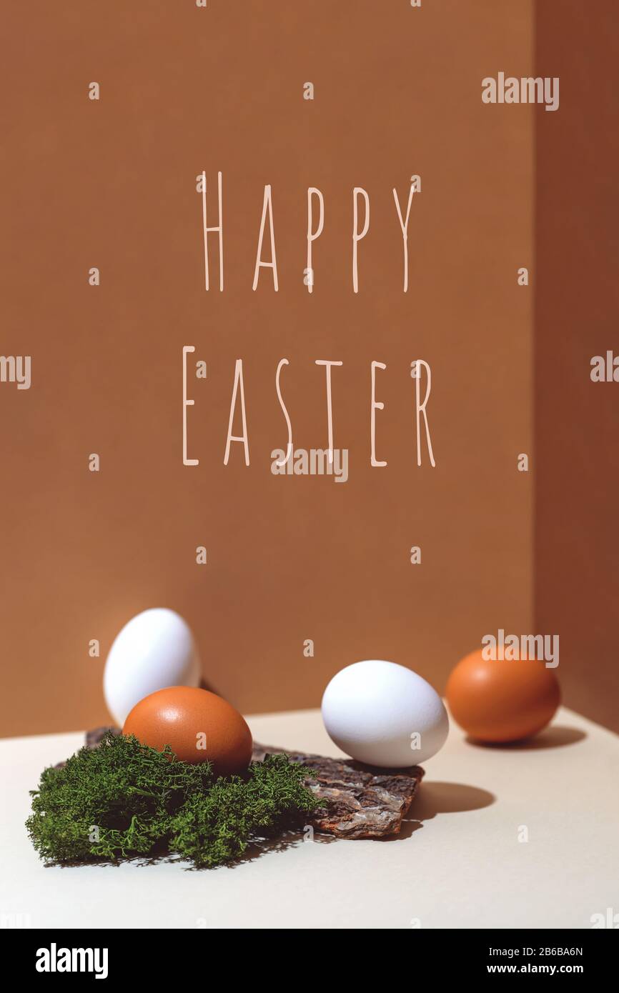 Four multi-colored eggs and natural materials moss and wood. Easter concept. Stock Photo