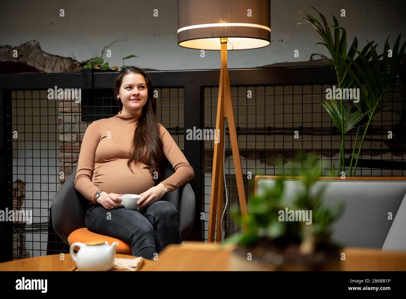 Pregnant woman sitting with cup of tea inside cafe Stock Photo - Alamy