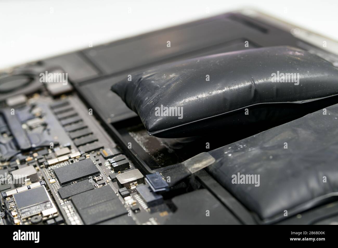Lithium-ion battery on laptop, which has expanded. Stock Photo