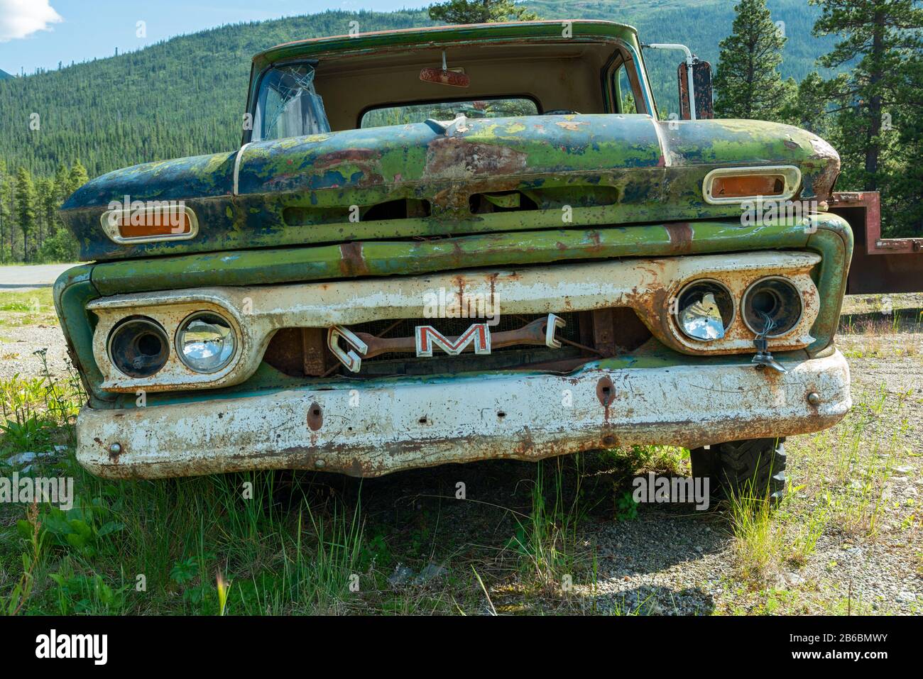 Cassiar, British Columbia, Canada - July 24, 2017: A rusty green GMC pickup in a junkyard Stock Photo