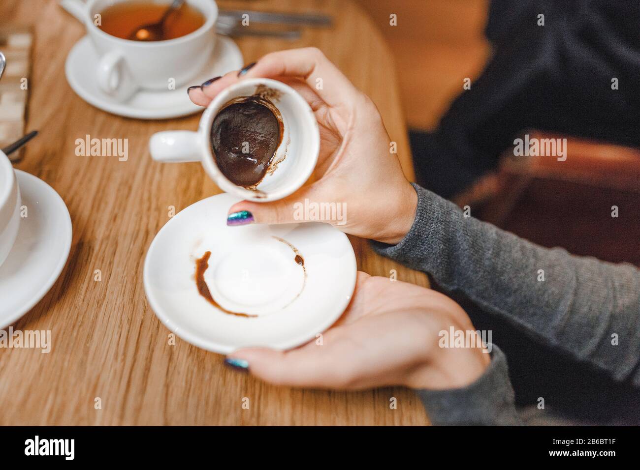 woman guessing on the coffee grounds in restaurant, concept of divination and fortune telling Stock Photo