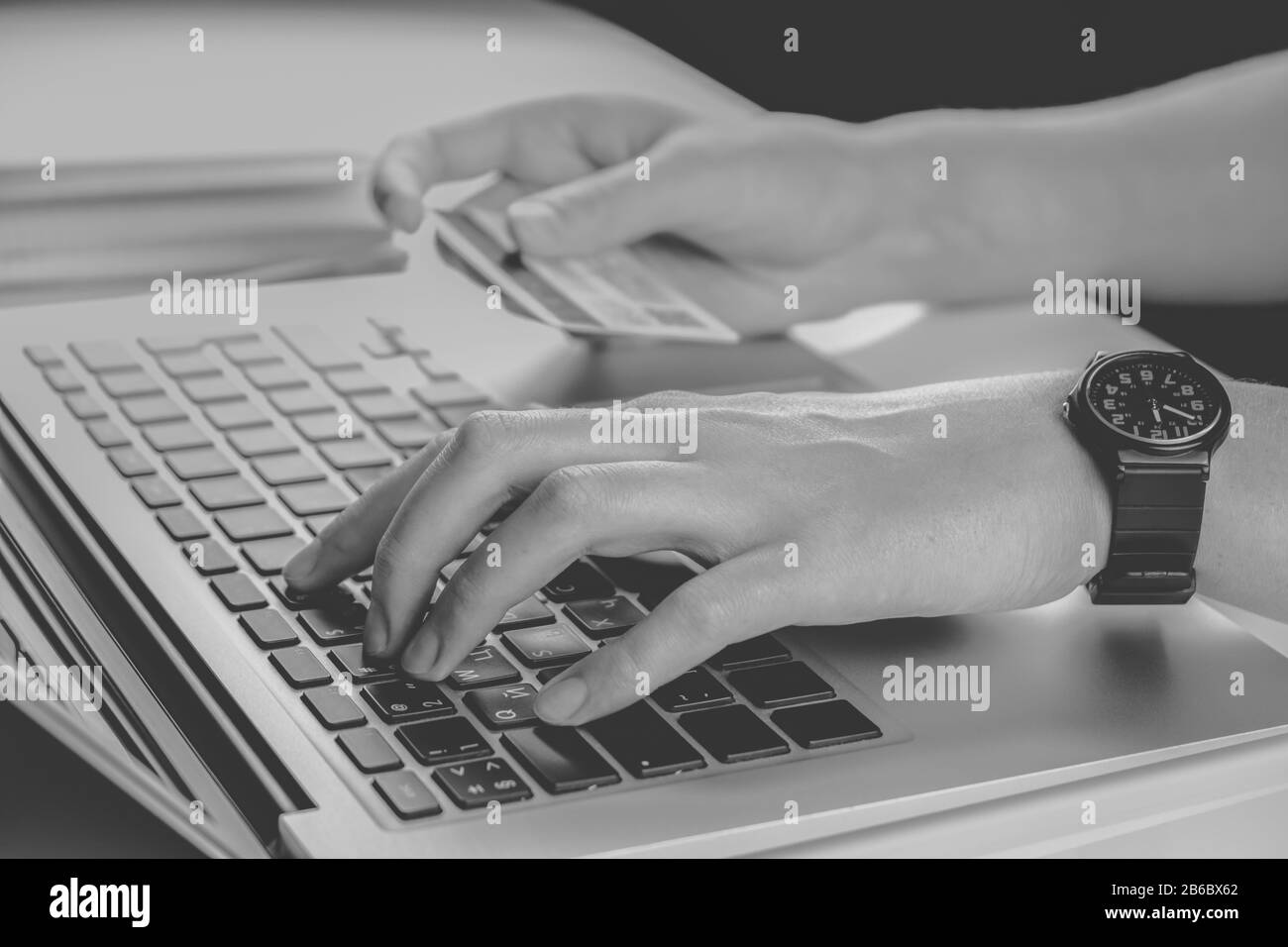 Using credit card for online payment, low key monochrome. Person filling bank account information while purchasing something in internet Stock Photo