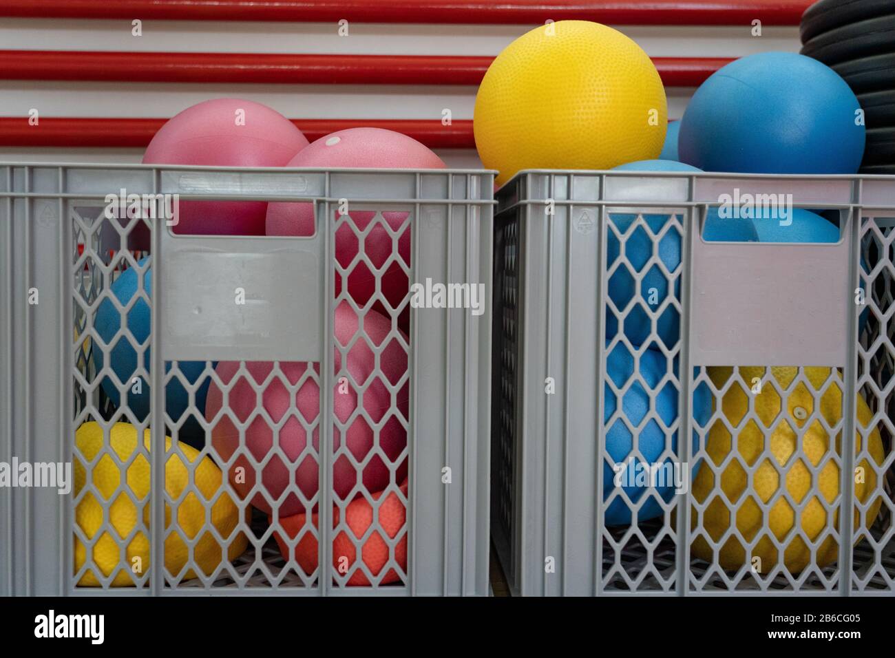 Two grey baskets with many colorful little gymnastic and yoga balls in a in a fitness center. Concept, close up. Stock Photo