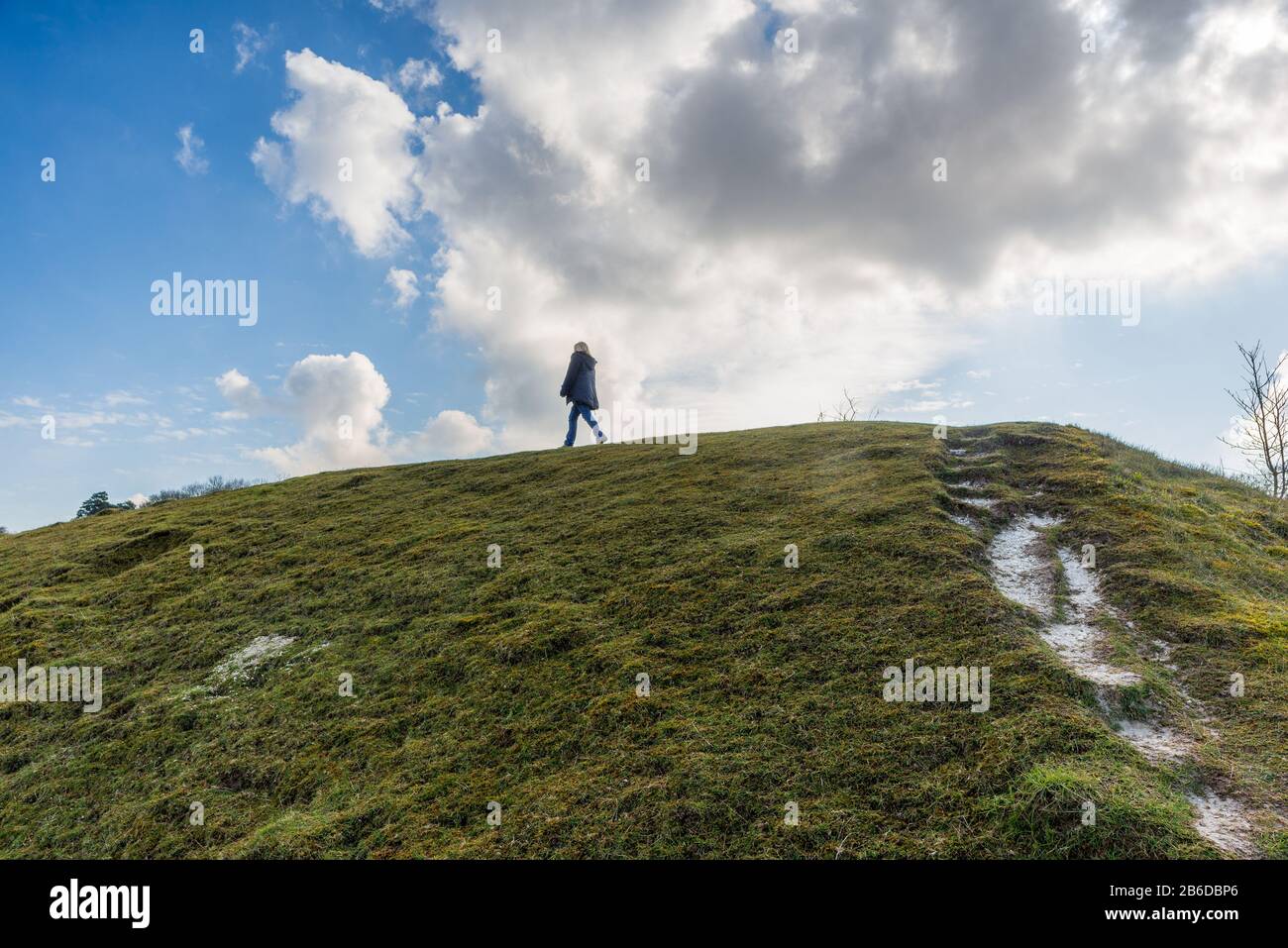 Woman walking on a hilltop in the English countryside in spring Stock Photo