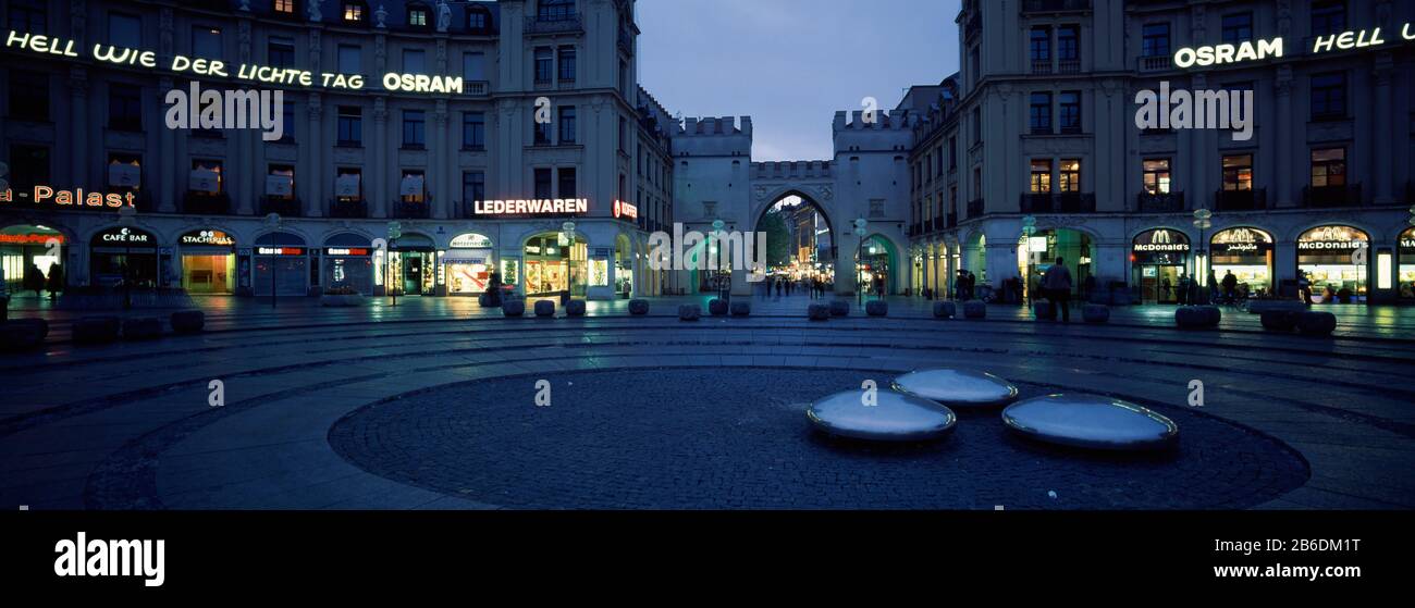 Buildings lit up at dusk at a town square, Karlsplatz, Munich, Bavaria, Germany Stock Photo
