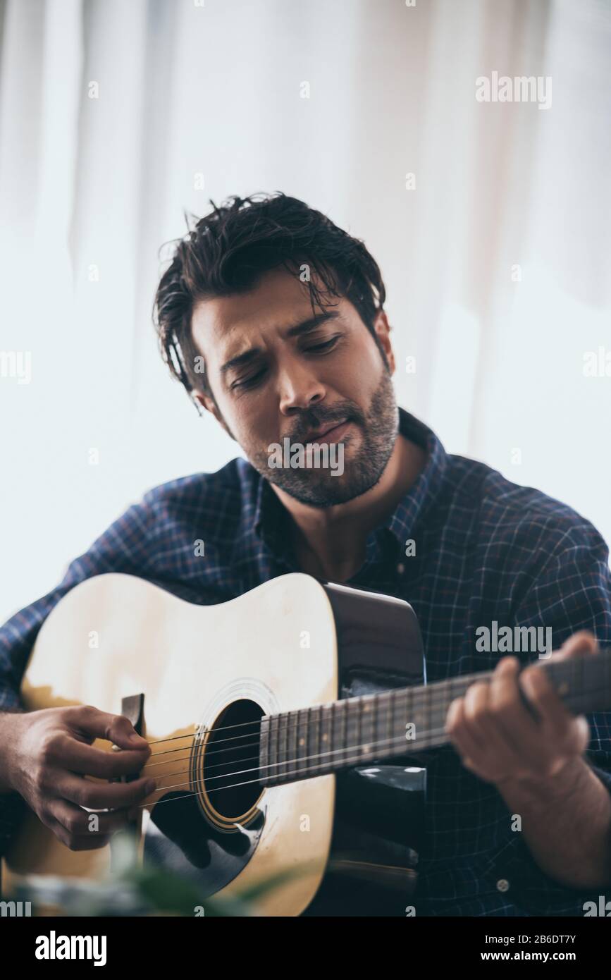 Practicing in playing guitar. Handsome young men playing guitar Stock Photo