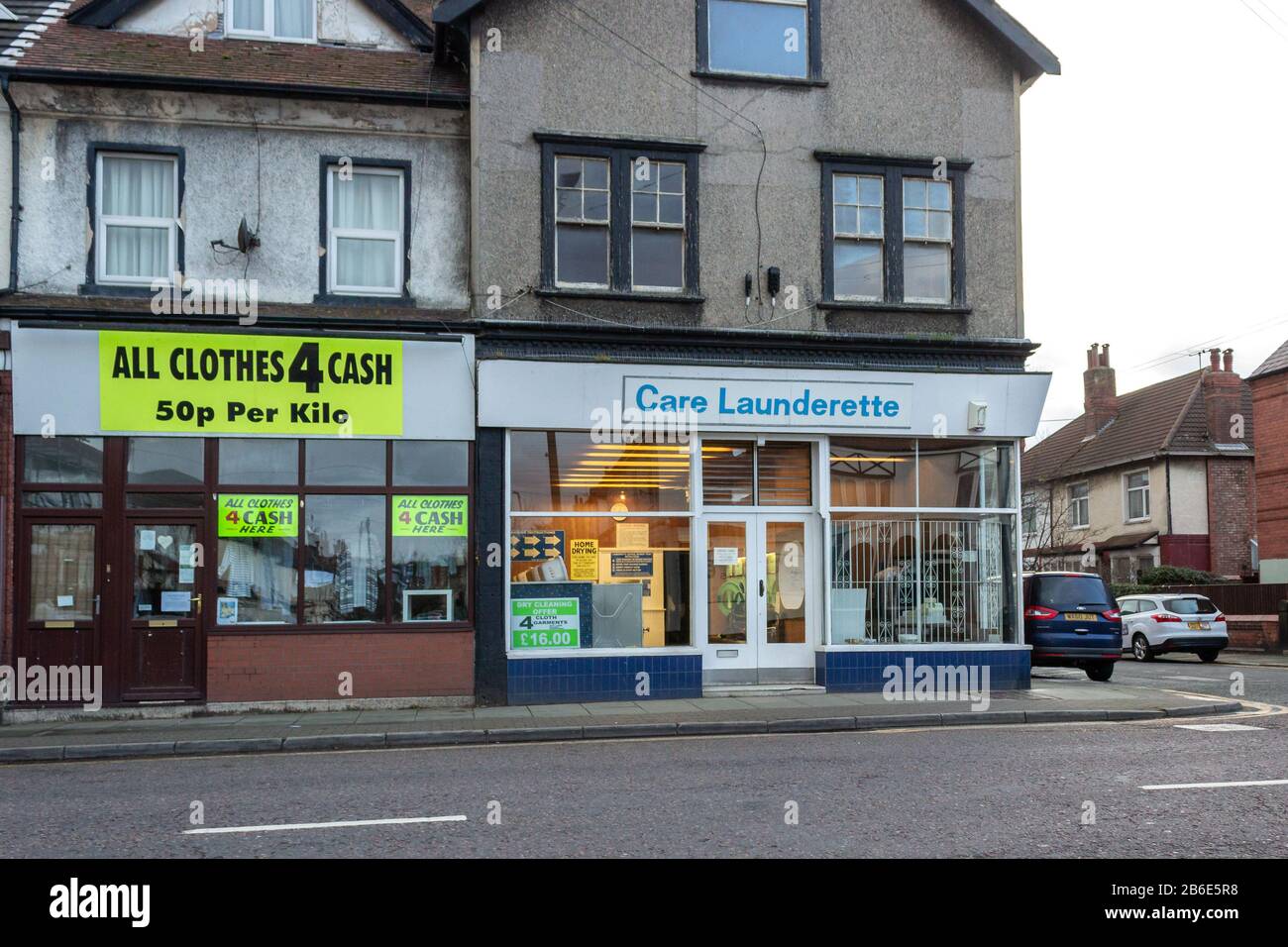 Second hand clothes store and Care Launderette, Harrison Drive, Wallasey Stock Photo