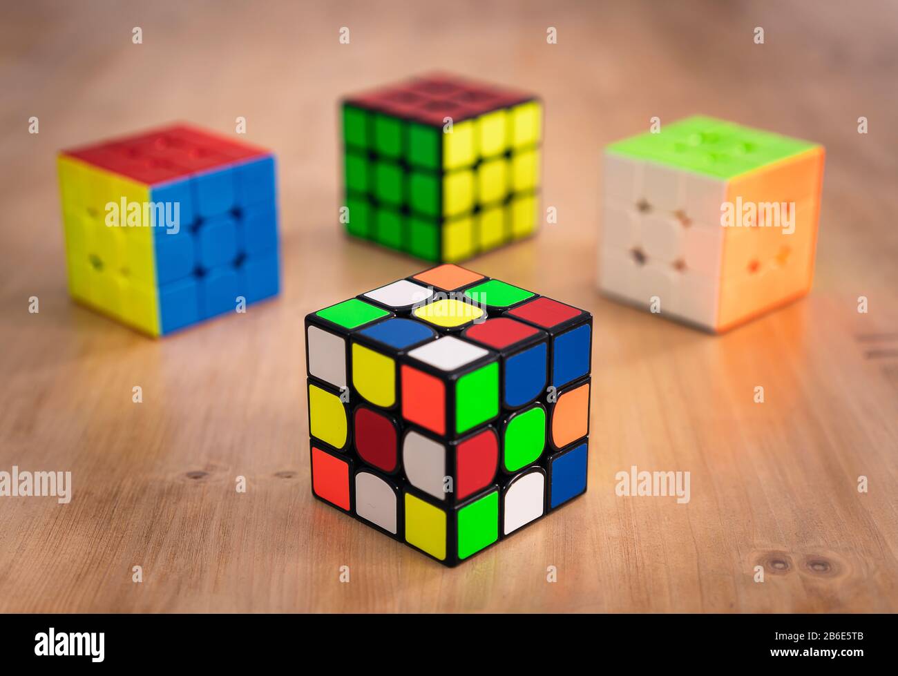 Several Rubik cubes intelligence toys unsolved, in a wood table Stock