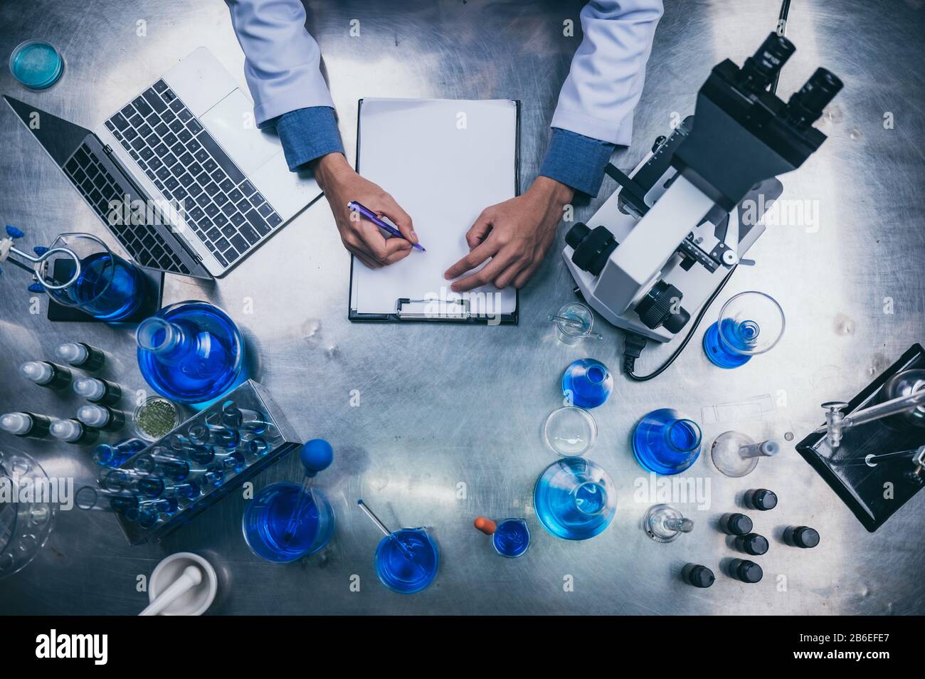 top view workspace in laboratory with microscope, laptop, and