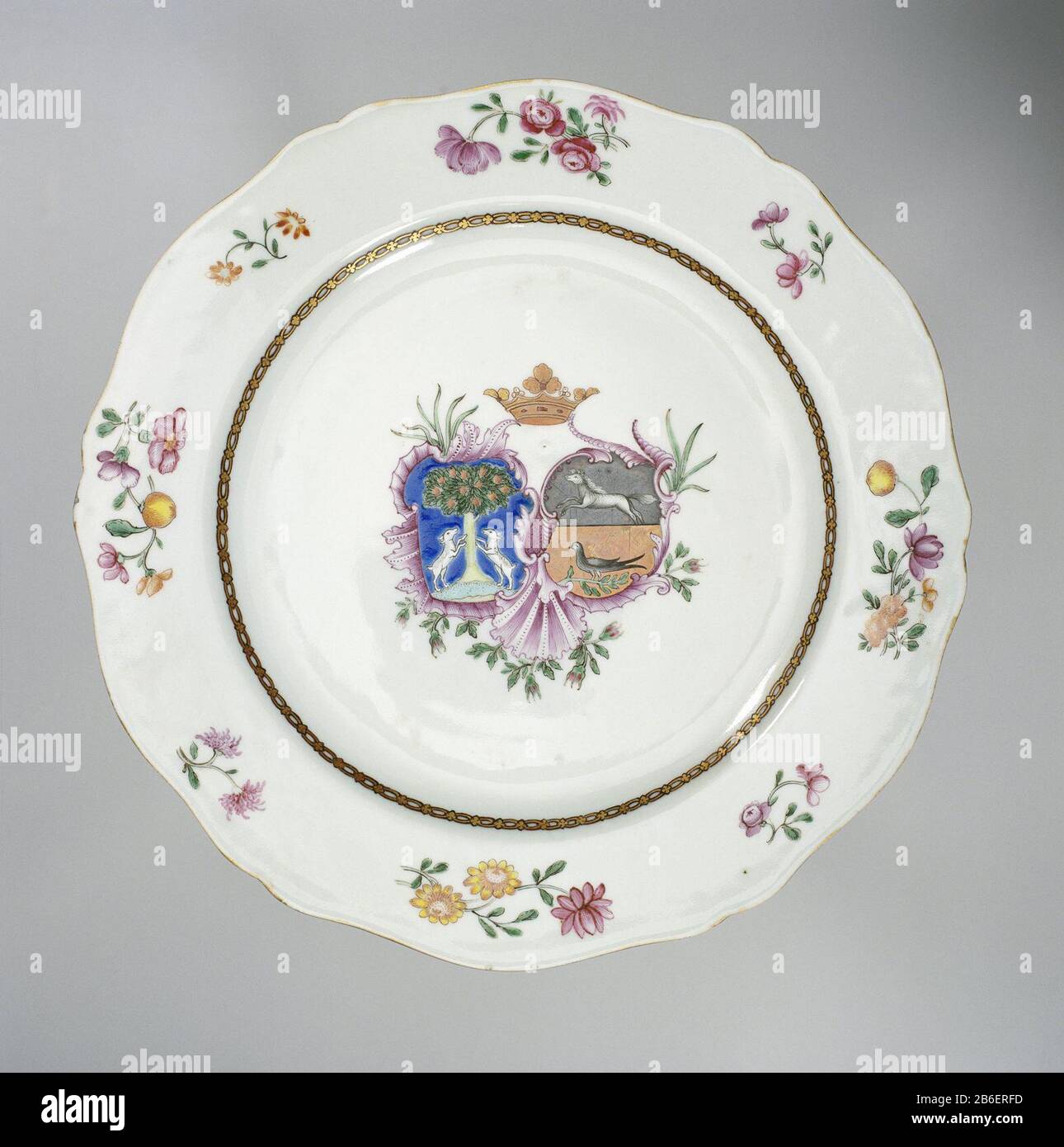 Plate with crowned coat of arms and flower branches Bord van porselein met geschulpte rand, beschilderd op glazuur in blauw, rood, roze, groen, geel, paars, zwart en goud. Op