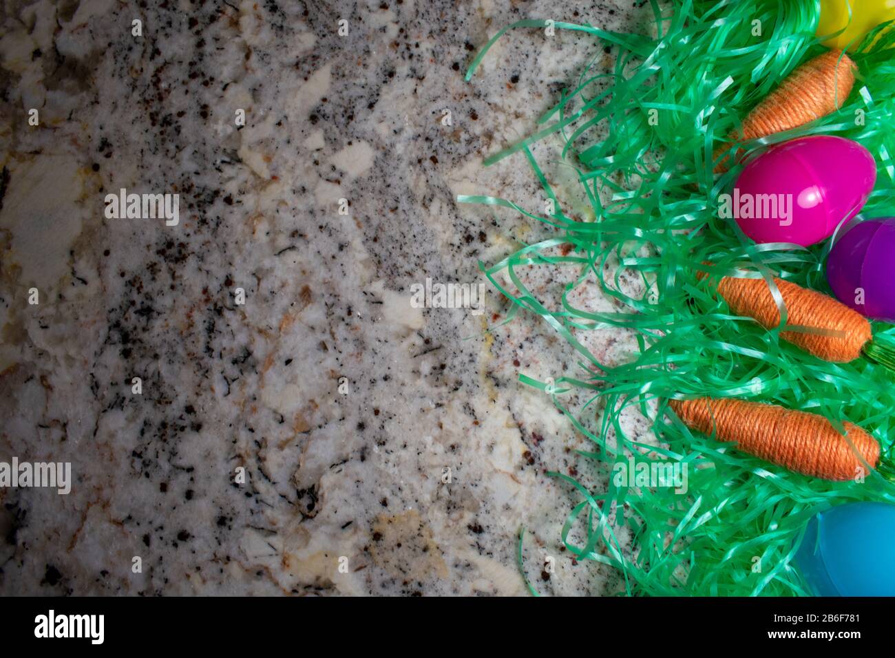 An Easter Flat Lay With Easter Grass, Carrots, and Eggs on a Granite Counter Top With Copy Space Stock Photo