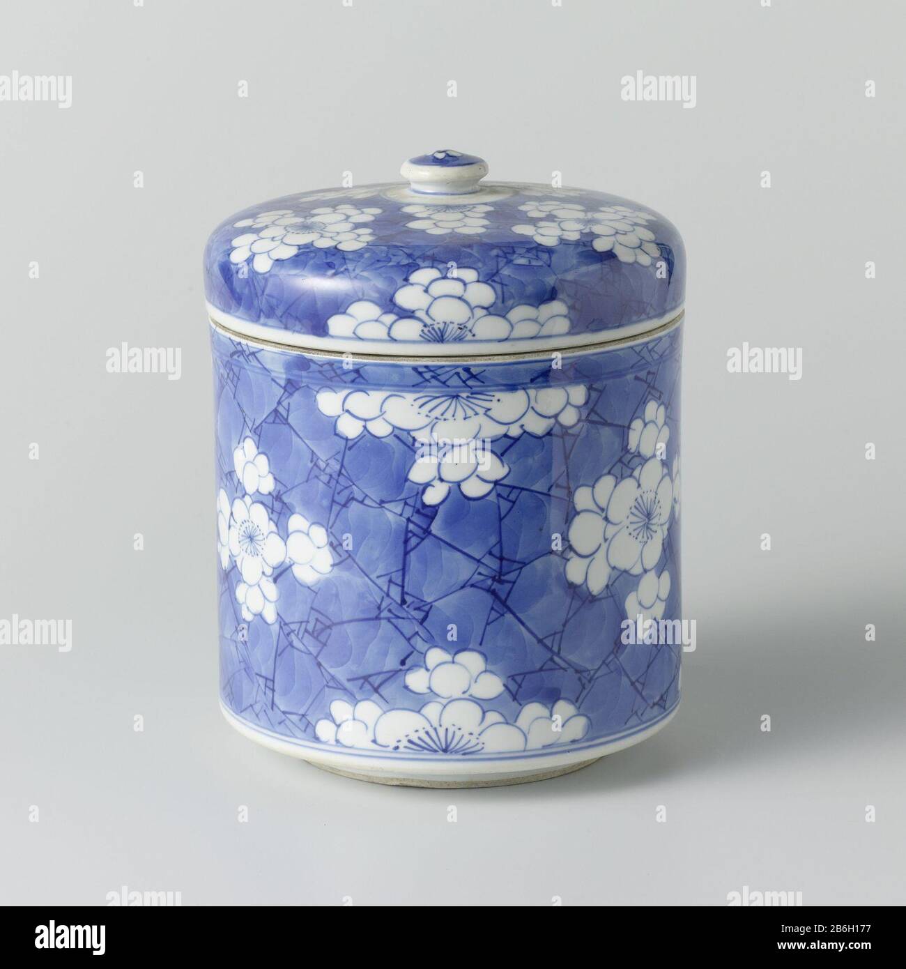 Cylindrical lidded with flowers in reserve Cilindrische dekselpot van porselein, beschilderd in onderglazuur blauw. Bedekt met een 'crackled ice' blauwe grond met pruimenbloesems in reserve. Een barst in de wand. Blauw-wit. Manufacturer : pottenbakker: anoniemPlaats manufacture: China Dating: ca. 1680 - ca. 1720School / stijl: Qing-dynastie (1644-1912) / Kangxi-periode (1662-1722) / Yongzheng-periode (1723-1735) Physical kenmerken: porselein met onderglazuur blauw Material: porselein glazuur kobalt Techniek: draaiend bewerken / bakken / schilderen / glazuren Dimensions: pot: h 12,4 cm. rand: d Stock Photo