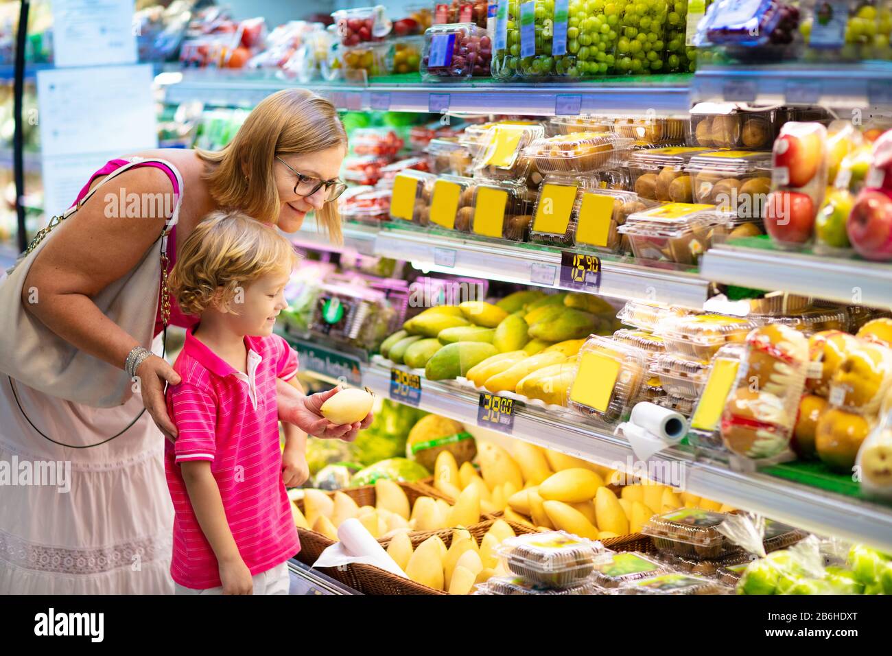 Shopping with kids. Mother and child buying fruit in supermarket. Mom