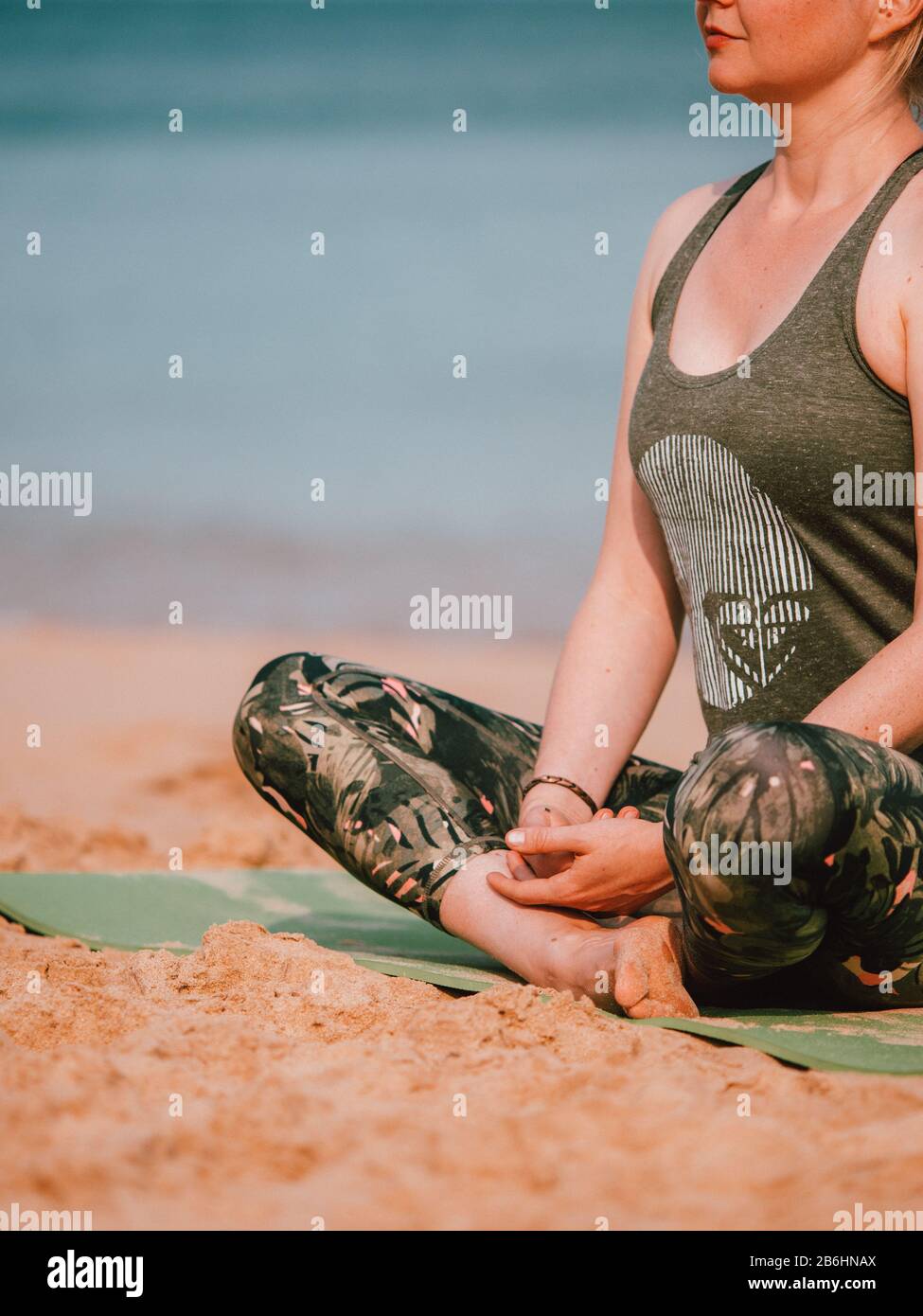 A woman leading a private yoga class on the beach in Western Australia Stock Photo