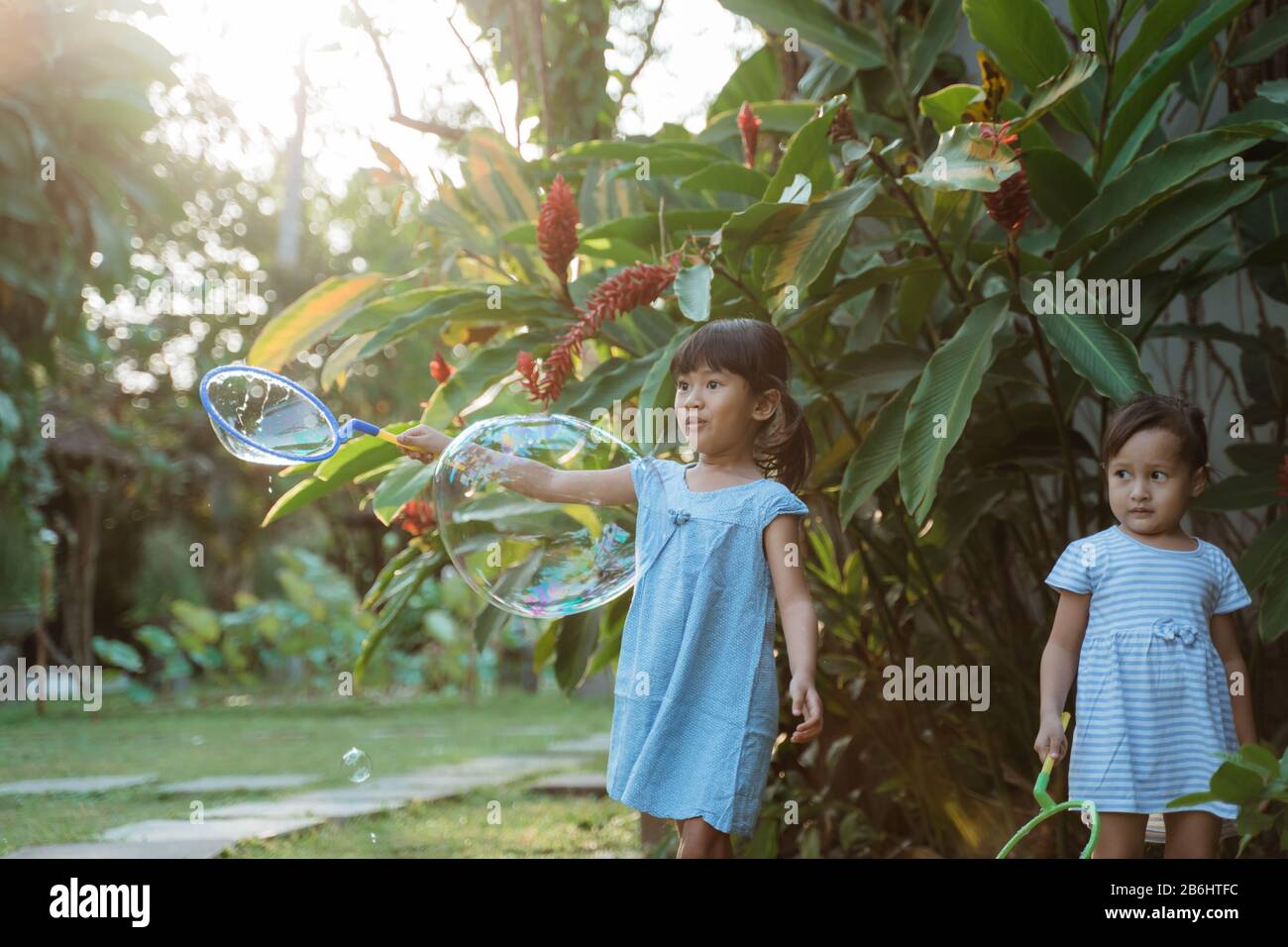 active little girl playing big bubble in the outside Stock Photo - Alamy