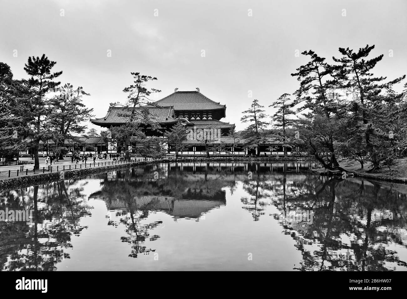 TOdai-ji temple complex in Nara city of Japan around still fish pond reflecting buildings and pine trees. Stock Photo