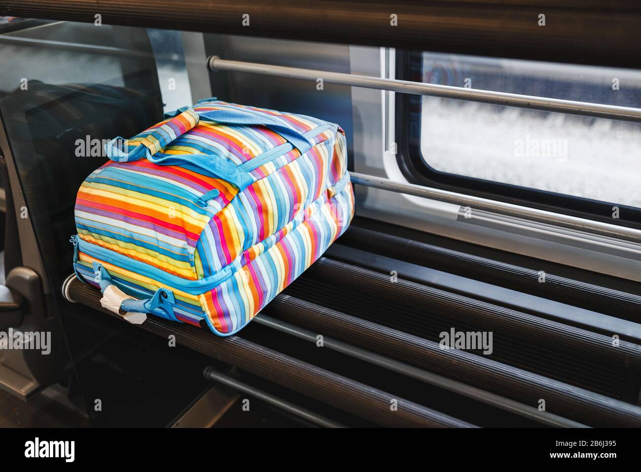 A colorful bag in the luggage compartment of the train with copy space for text Stock Photo Alamy