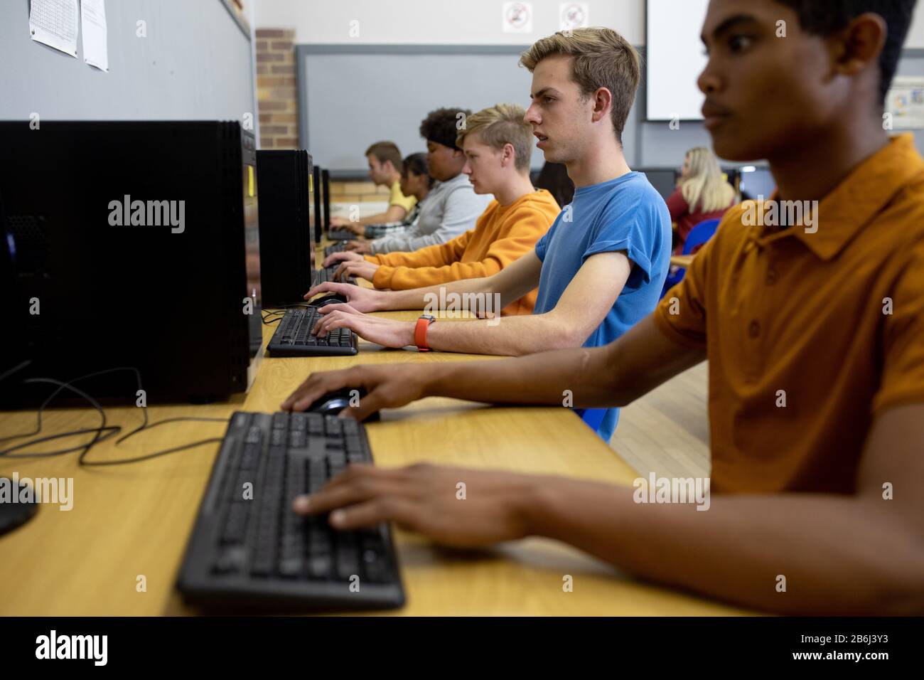 Side view of students working on computers Stock Photo