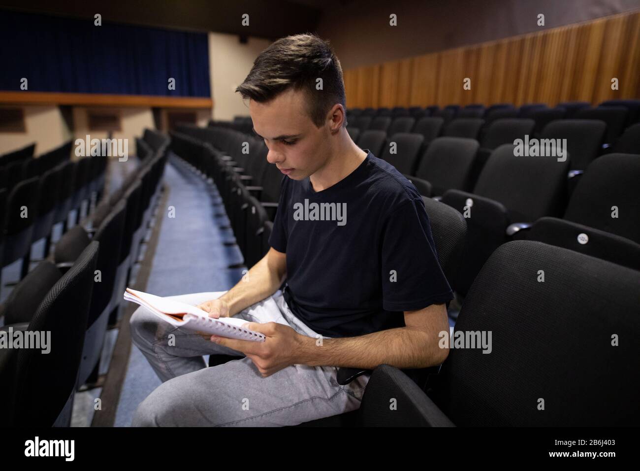 Side view of student reading a text in a theater Stock Photo